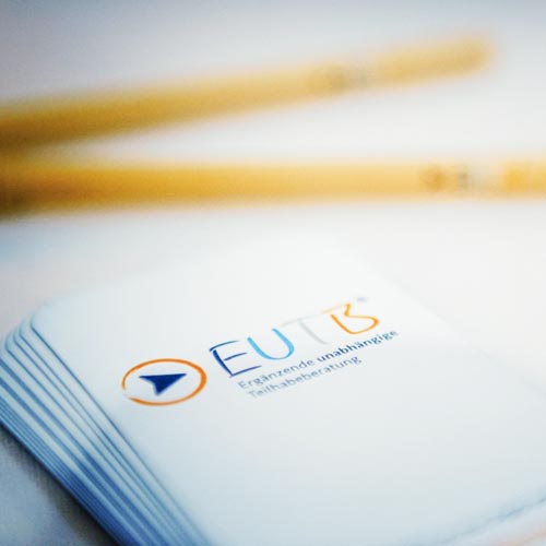 Zeigt einen Stapel Karten mit dem Logog von EUTB. 
